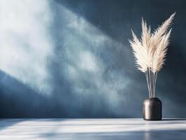 A minimalist arrangement of pampas grass in a dark vase against a textured blue background. photo