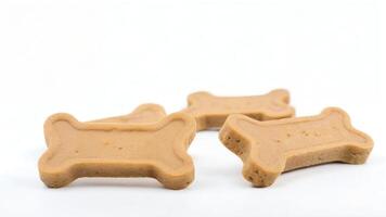 Four bone-shaped dog treats on white background. photo