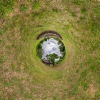 A circular hole in the ground with grass and trees photo