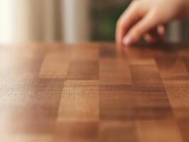 A close-up of a wooden surface with a hand reaching towards it. photo