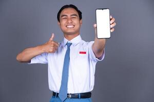 Indonesian Male High School Student in Uniform Smiling While Holding Phone Background photo
