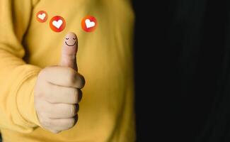 Man and show happy smiley face on thumb up with red heart emotion. Client satisfaction surveys and review. photo