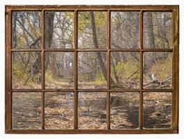 nostalgic fall landscape along a river, view from a vintage window photo