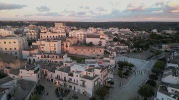flight over the center of Alberobello. city is famous not only for amazing architecture of the Truli houses, but also for true architecture of Italy. white houses with tiled roofs in the setting sun video