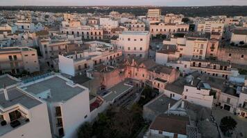 flight over the center of Alberobello. city is famous not only for amazing architecture of the Truli houses, but also for true architecture of Italy. white houses with tiled roofs in the setting sun video