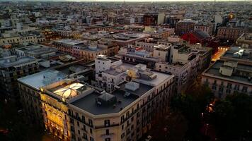 Sunset flight over city of Bari in Italy. Buildings are painted in rays of setting sun. Warm sunset in Bari. Modern architecture next to historical buildings. Bari is the center of tourism in Italy video