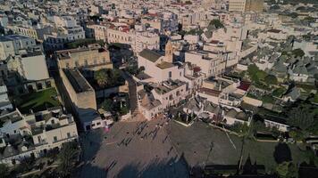 flight over the center of Alberobello. city is famous not only for amazing architecture of the Truli houses, but also for true architecture of Italy. white houses with tiled roofs in the setting sun video