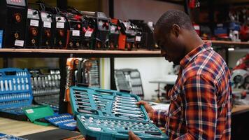African Man Examining Comprehensive Tool Set in Hardware Store video