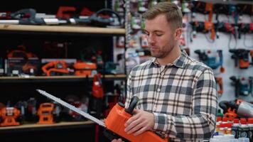 A Man Inspecting a Chainsaw in a Hardware Store video