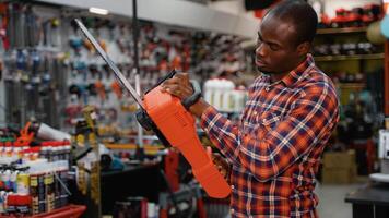 A Man Choosing a Chainsaw in a Hardware Store video
