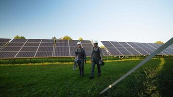 Workers Carry Tools Across Solar Panel Field video