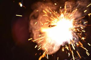 A sparkler is being lit up by a person photo