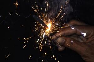 A person holding a sparkler in their hand photo