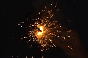 A person holding a sparkler in their hand photo