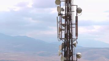 telecommunication tower in front of overcast sky and mountains on horizon video