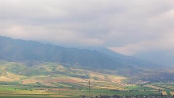 telecommunication tower in front of agricultural field and mountain range video