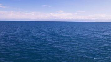 flat blue surface of large mountain lake at sunny day with mountains on the horizon video
