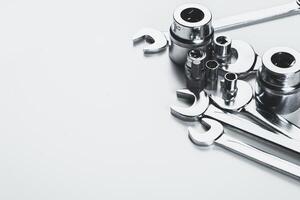 Various metallic hand tools arranged on a light surface, showcasing their functionality and design in a workshop setting photo