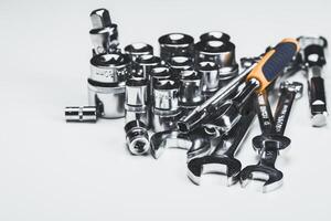 Various tools laid out for a mechanical task on a plain surface, showcasing the variety of socket wrenches and ratchets photo