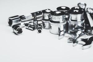 Assorted metal tools arranged on a white background for repair and maintenance tasks in a workshop setting photo
