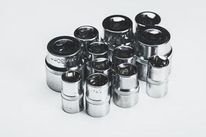 Collection of chrome socket tools arranged on a neutral background for automotive repair and maintenance tasks photo