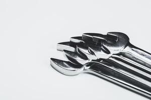Collection of shiny wrenches arranged neatly on a light background showcasing tools for mechanical work or repair photo