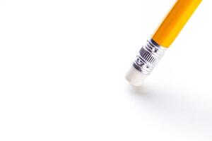Close-up view of a yellow pencil eraser resting on a plain white background showcasing its details and design elements photo
