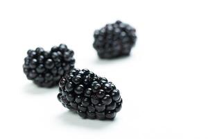 Fresh blackberries arranged on a clean white surface ready for consumption or culinary use at any time photo