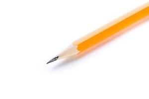 Close-up of a sharpened yellow pencil resting on a white surface capturing the essence of creativity and study photo