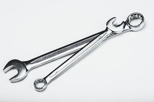 Different sizes of metallic wrenches placed on a plain surface showcasing their functionality and design photo