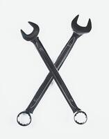 Crossed wrenches positioned on a light background showcasing tools commonly used in mechanical work photo