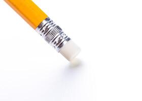 Close-up of a yellow pencil with an eraser against a clean white background illuminated by soft light photo