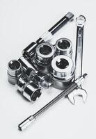 Collection of metallic hand tools arranged on a smooth surface showcasing their shine photo