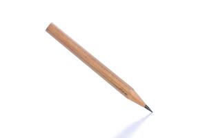 Wooden pencil placed at an angle on a white surface with a sharp point for writing and drawing activities photo