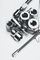 Collection of various metallic tools arranged on a flat surface showcasing their intricate details and designs for mechanical work photo