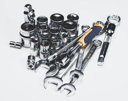 Assorted hand tools and sockets arranged on a flat surface for automotive repair or mechanical tasks photo