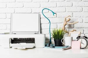 Workspace setup with printer, desk lamp, and decorative elements in a modern office photo