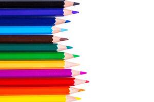 Colorful assortment of colored pencils arranged in a vibrant lineup on a clean white surface photo