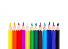 Colorful collection of sharpened pencils arranged in a straight line against a plain white background photo