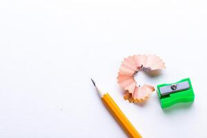 Pencil sharpening supplies on white background with pencil shavings and sharpener in bright colors photo