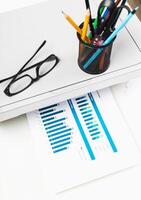 Office workspace with charts and eyeglasses, showcasing productivity in a modern environment photo
