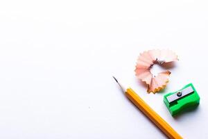 Pencil, sharpener, and shavings on white background create a simple workspace scene photo