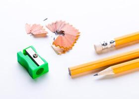 Bright yellow pencils and sharpener with wood shavings on a clean surface in a study area photo