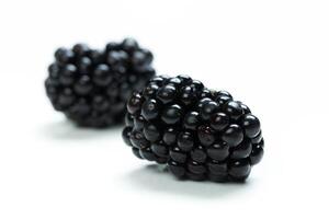 Fresh blackberries placed on a clean white surface, highlighting their rich color and texture photo