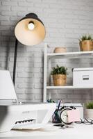Organized workspace with printer, clock, lamp, and plants in a modern office setting during daytime photo