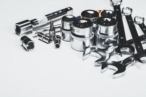 Assortment of shiny tools including sockets and wrenches on a light background for mechanic work or DIY projects photo