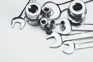 Various metal tools arranged neatly on a light surface in a workshop setting for repair tasks photo