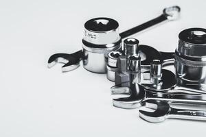 Various metal tools arranged neatly on a light surface in a workshop setting for repair tasks photo