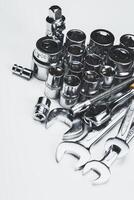 Tools arranged neatly on a white surface ready for a mechanical repair task in a workshop setting photo