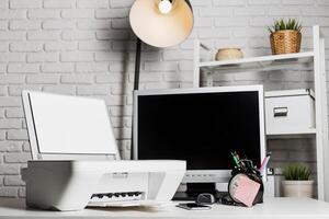 Workspace featuring computer, printer, clock, and stationery in a bright setting with modern decor photo